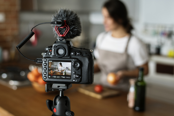 A imagem contém uma pessoa sendo gravada ao preparar algo culinário. A profissão influencer está em todos os lugares.