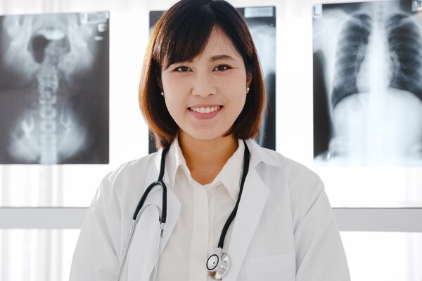 A imagem contém uma médica sorridente