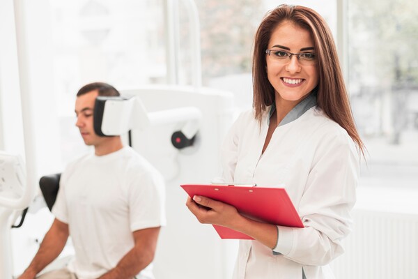 A imagem contém uma médica sorridente exercendo a saúde ocupacional.