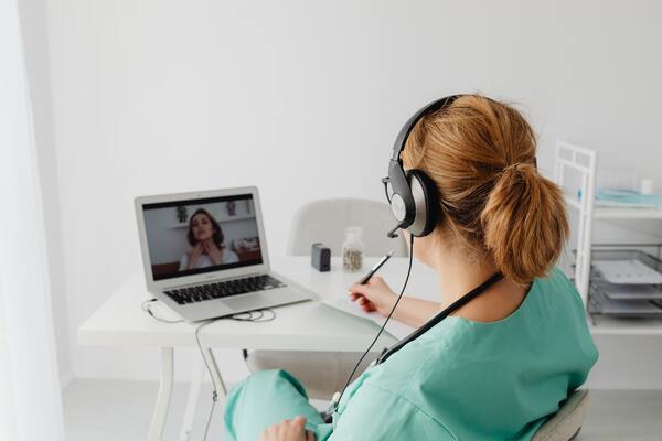 A imagem contém uma médica usando uma tecnologia na Medicina: o teleatendimento.