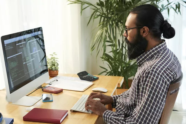 A imagem contém um profissional formado em Análise e Desenvolvimento de Sistemas programando em seu notebook.